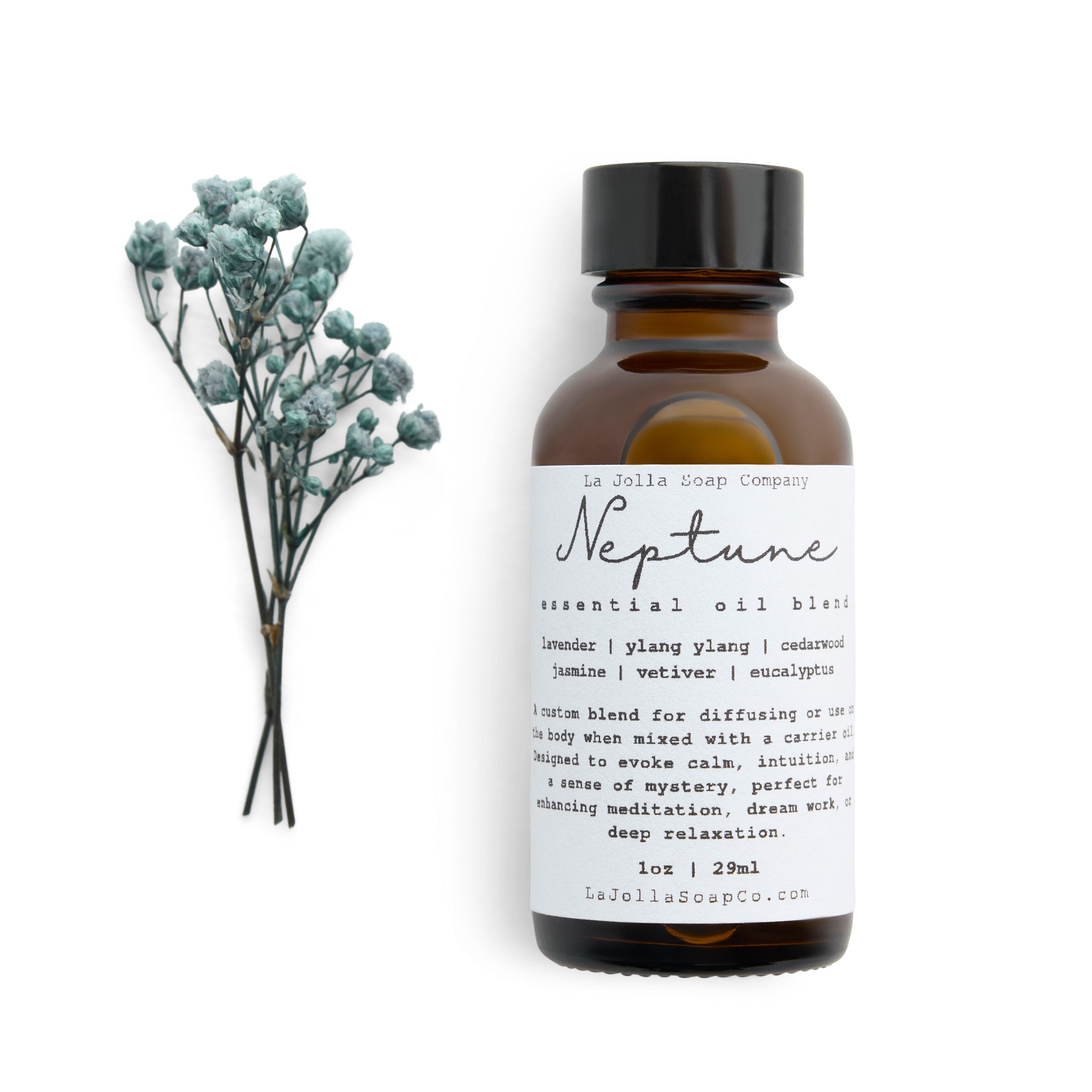 A bottle of Neptune Essential Oil Blend with a small bouquet of dried blue flowers laid in front, set against a clean natural white backdrop, evoking the calming and refreshing essence of the ocean.