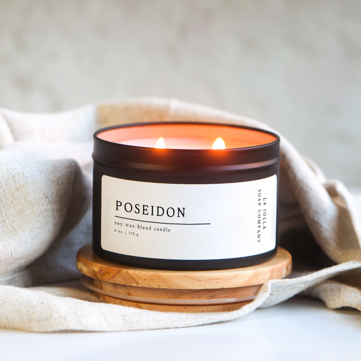 Poseidon candle in a black tin, with scent notes of tobacco, cypress, eucalyptus, and bay leaf, evoking the rugged, natural essence of the sea in a hand-poured , luxurious candle.