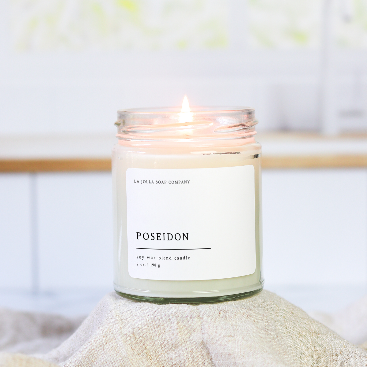 Poseidon Candle in a glass jar, with scent notes of tobacco, cypress, eucalyptus, and bay leaf, evoking the rugged, natural essence of the sea in a hand-poured, luxurious candle