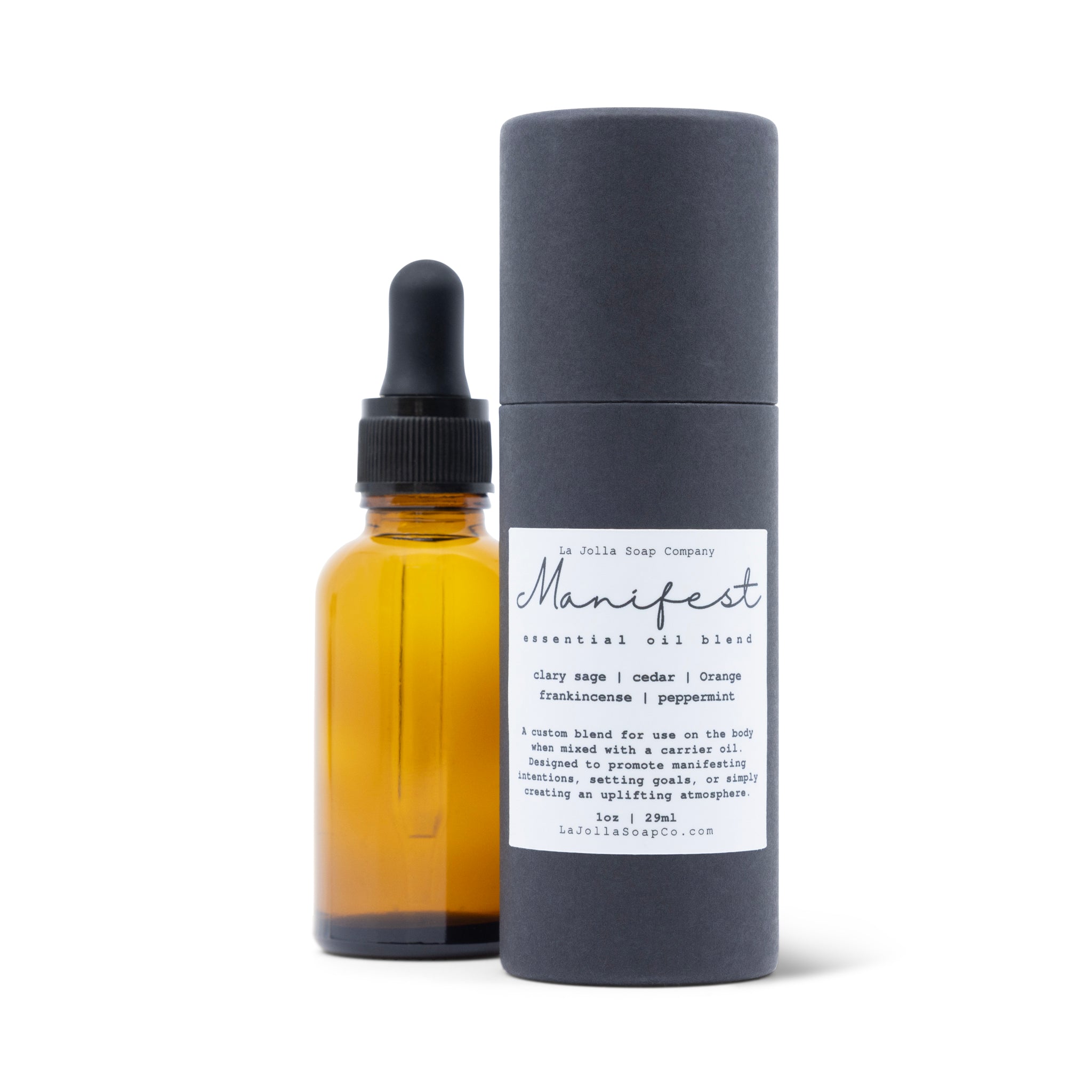 A bottle of Manifest Essential Oil Blend set next to the sleek packaging, black paper tube with hand script label in front, set against a clean, natural white background, evoking a sense of renewal.
