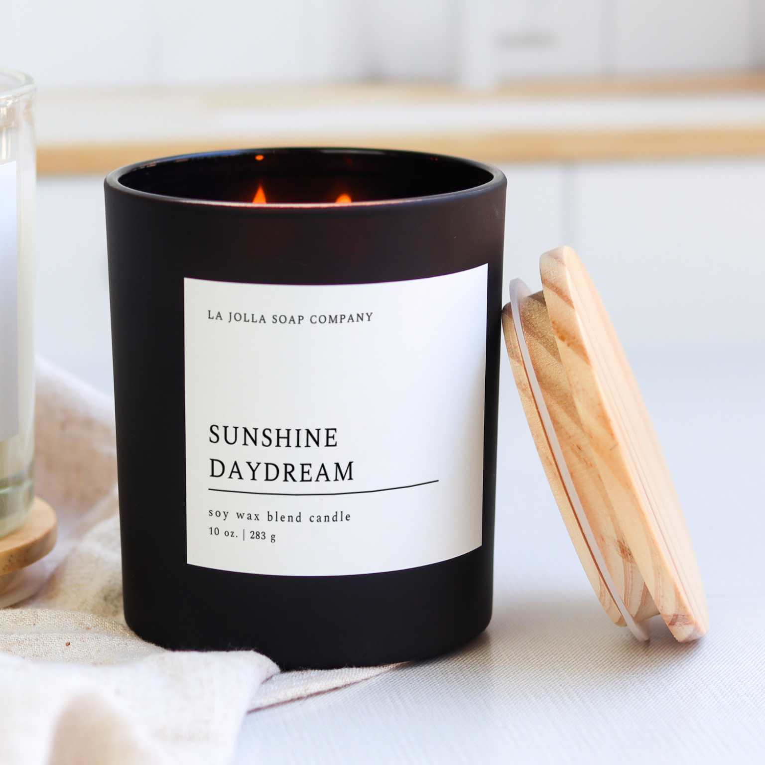 10 ounce Sunshine Daydream candle in a sleek black jar with a minimalist label, photographed against a clean background.