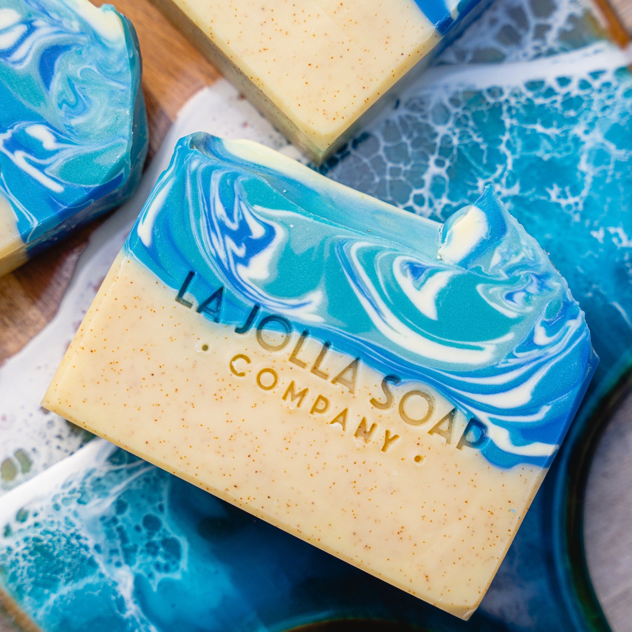 Artfully handcrafted with moisture rich oils and butters. Inspired by the ocean waves crashing along the cove. The whirl of blue colors tumbling with peaks of white foam. The seashore is sprinkled with finely ground walnut shell which lend some exfoliation. The scent is unisex, uplifting and fun with fresh marine notes, sea cypress, twists of citrus and a touch of coconut cream.