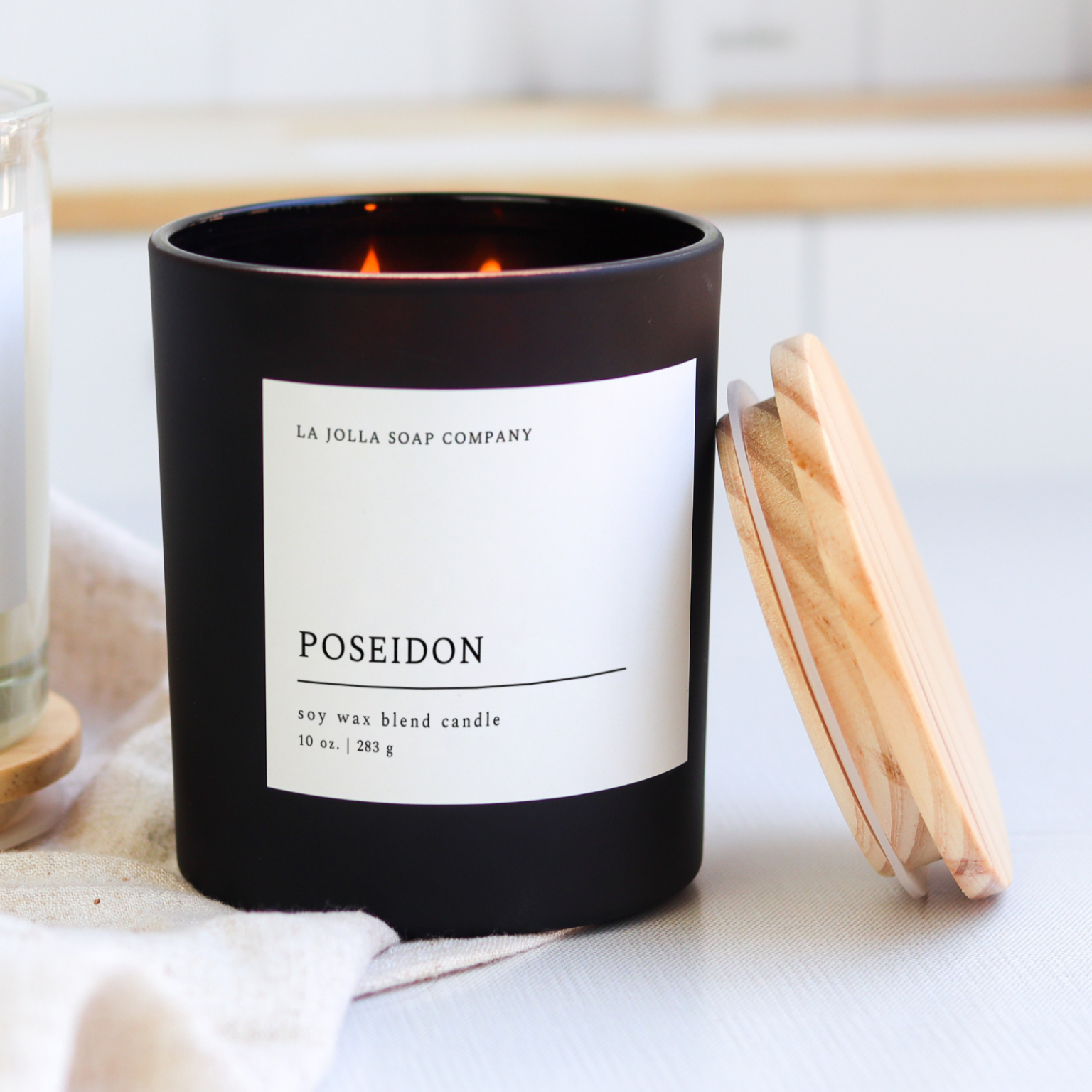 Poseidon Candle in a glass jar, with scent notes of tobacco, cypress, eucalyptus, and bay leaf, evoking the rugged, natural essence of the sea in a hand-poured, luxurious candle