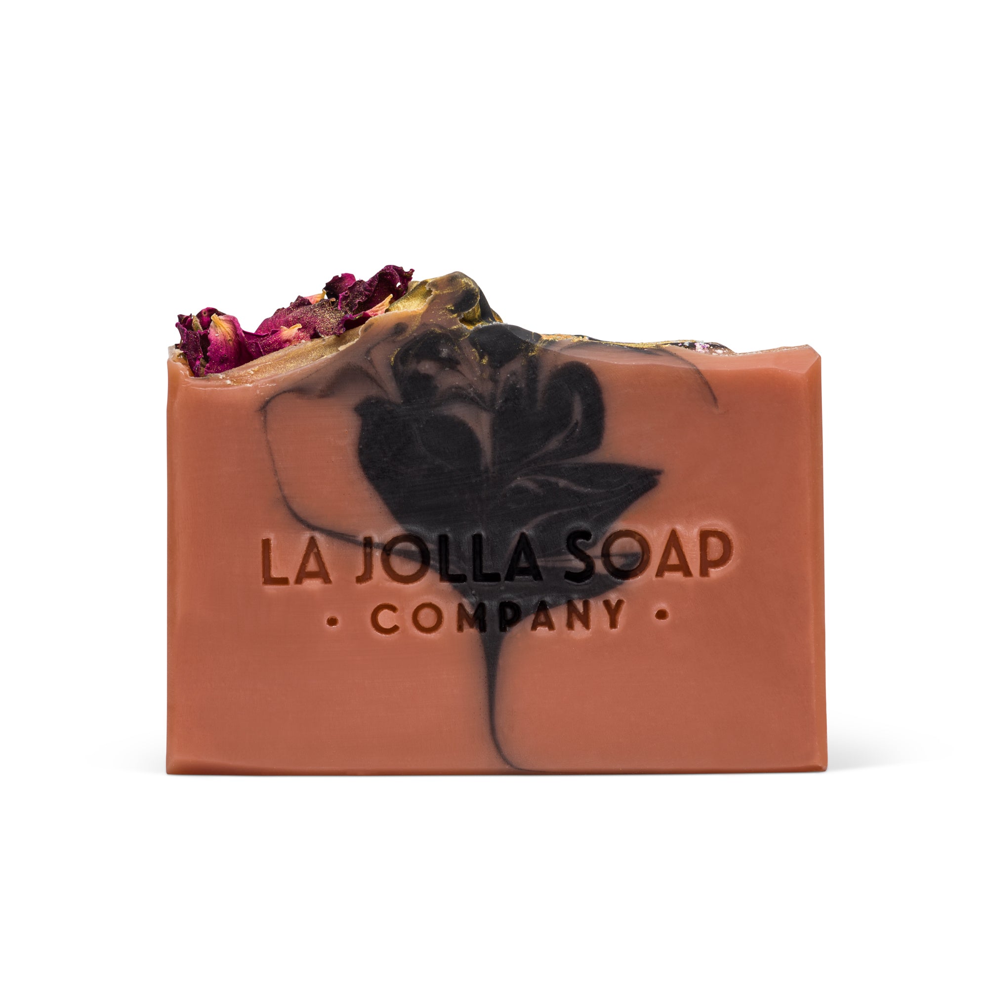 Bar of soap with black flower design and dried flowers on top, branded 'La Jolla Soap Company'.