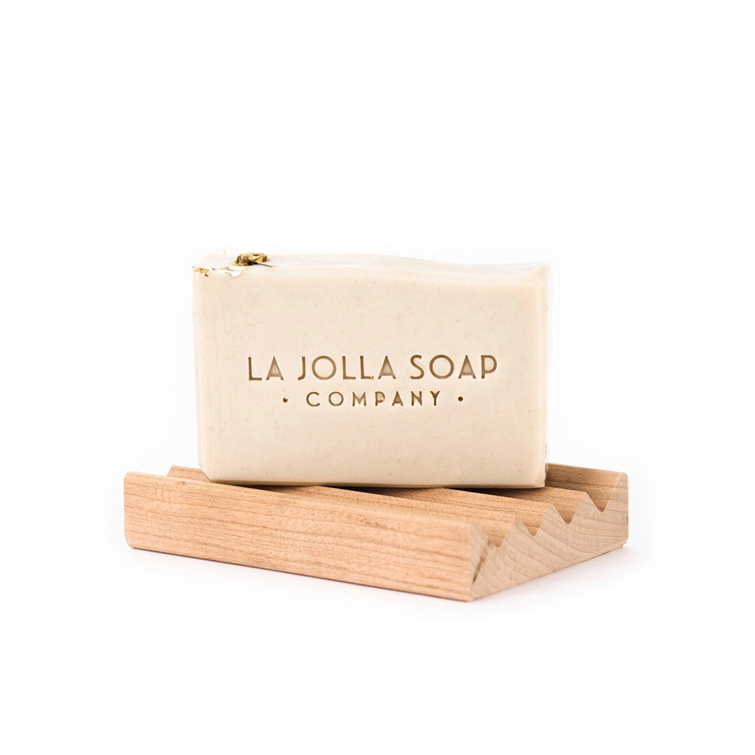 White natural soap bar a top a natural wood, one peace design - wave soap deck.  La Jolla Soap Company